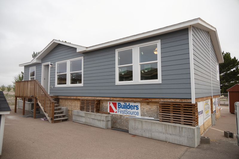 A new blue house with white trim on a platform that was built by students at the MiLL. 