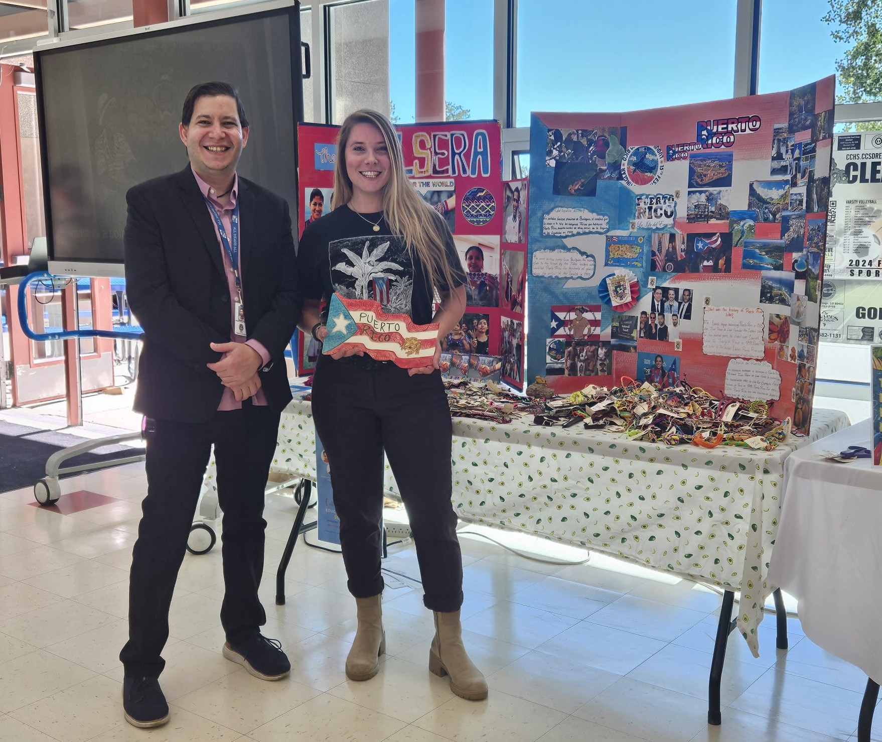 Representatives from CDE and MYN holding a ceramic sculpture depicting the Puerto Rican flag. 